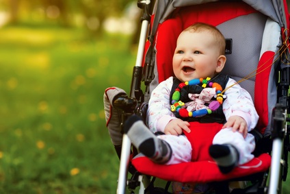 Bébé dans sa poussette rouge